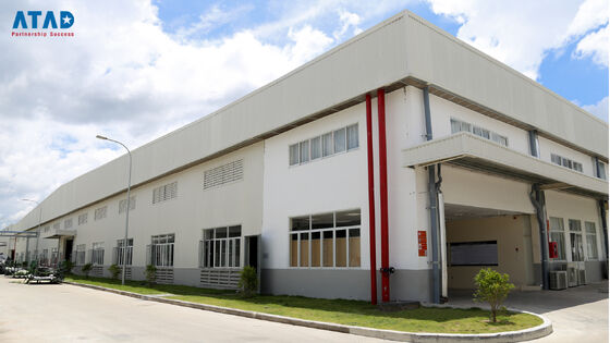 Een groot kantoorgebouw met een voorgewerkt staalconstructie met een scheef dak en betonnen fundering